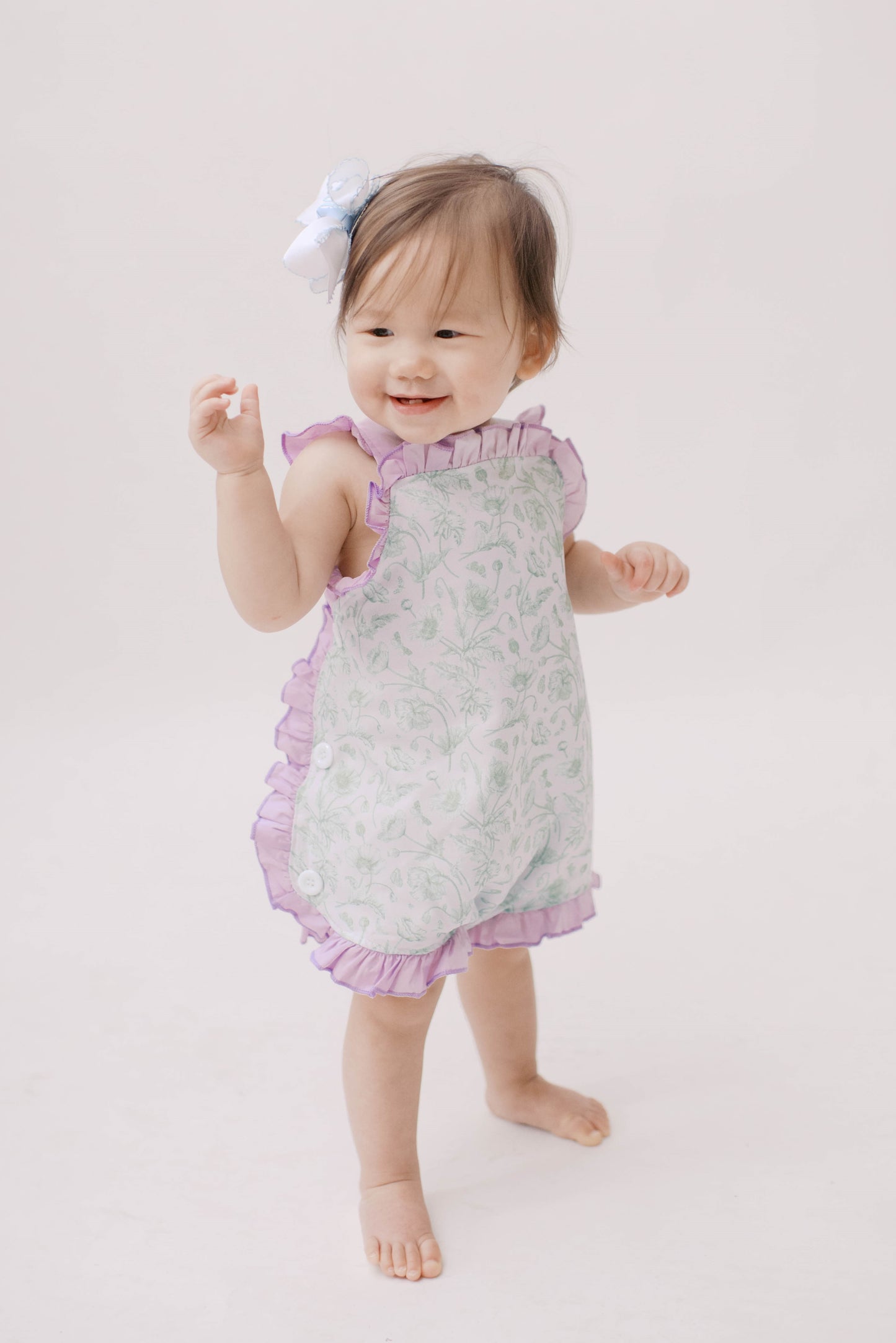 Girl green toile playsuit bubble romper with purple tie back.